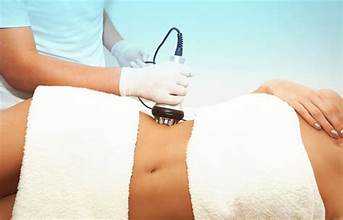 womans body draped in spa towel receiving cavitation fat reduction service